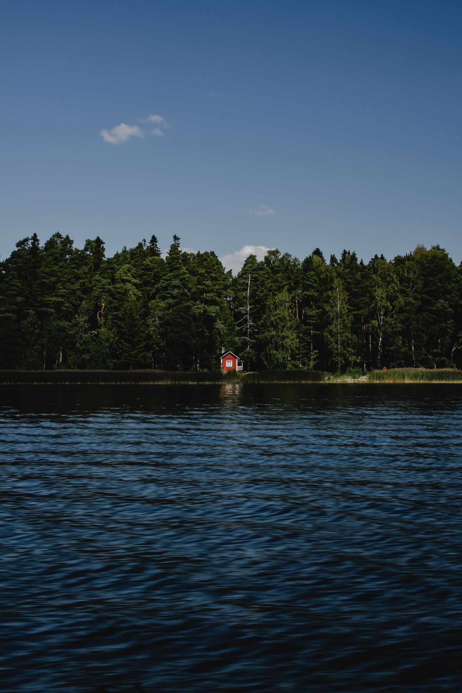 Punainen mökki suomalaisen järven rannalla