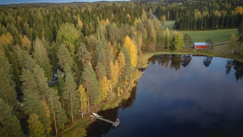 Ruska ja mökki järven rannalla