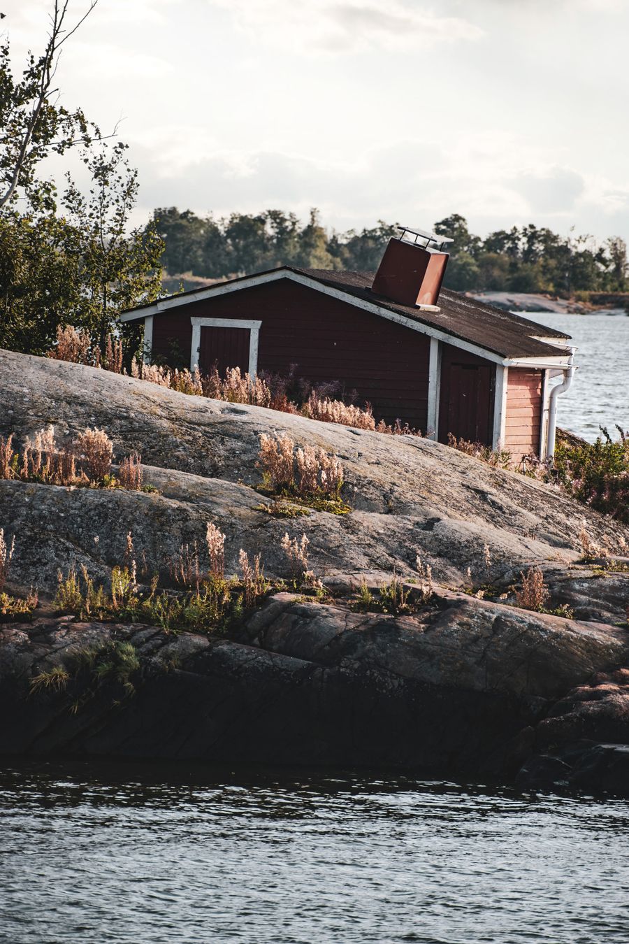 Punainen mökki kalliorannalla