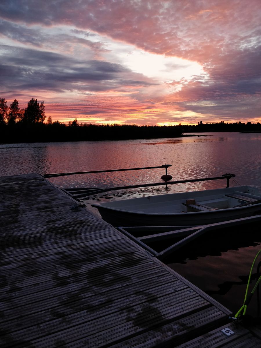 Laituri ja vene järvellä auringonlaskussa