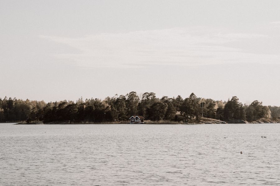 Mökki metsäisen saaren rannalla